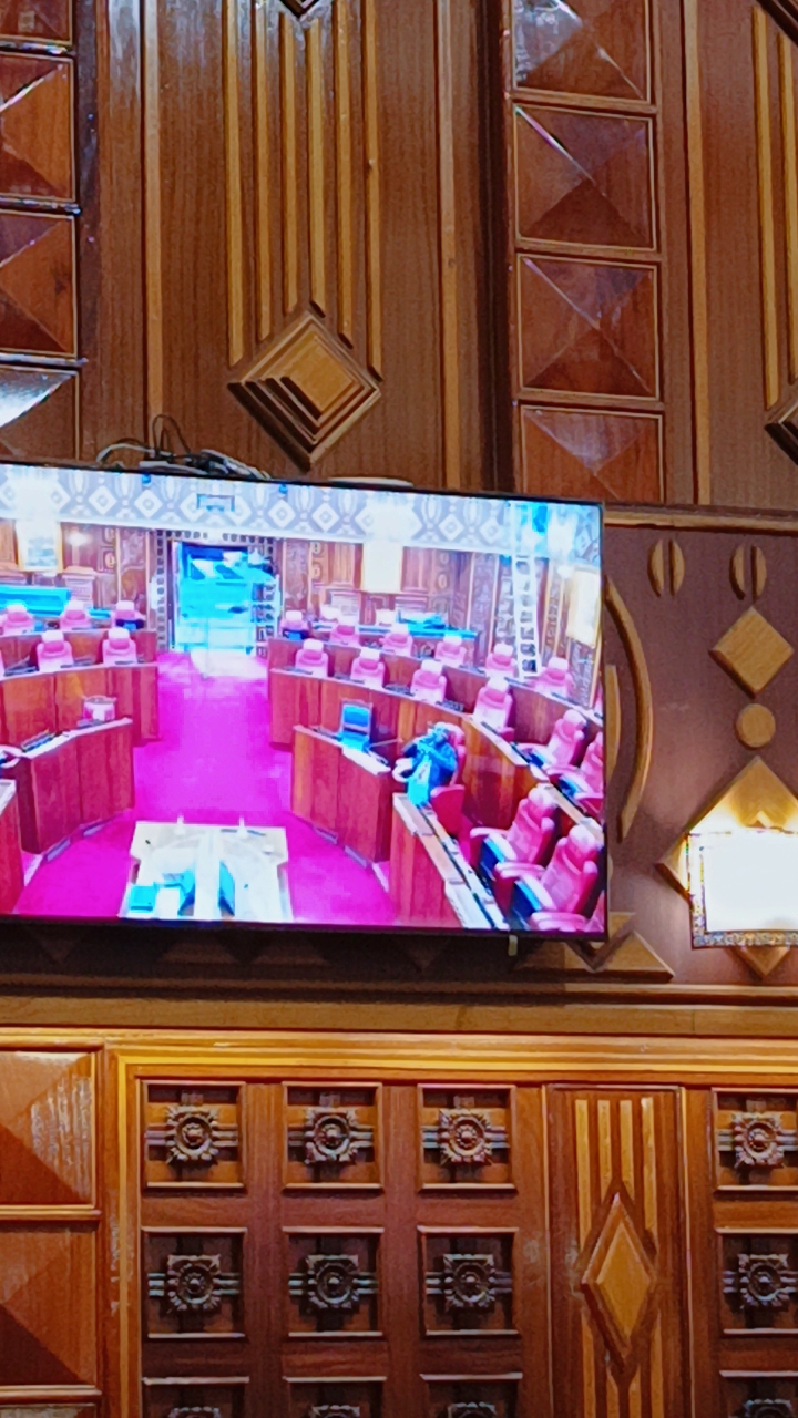 Chamber display screen showing live coverage of the parliamentary chamber